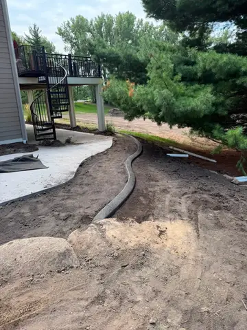 Concrete edging leading to patio under deck in Princeton, MN