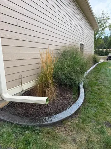 Concrete border surrounding ornamental grasses near home in Princeton, MN
